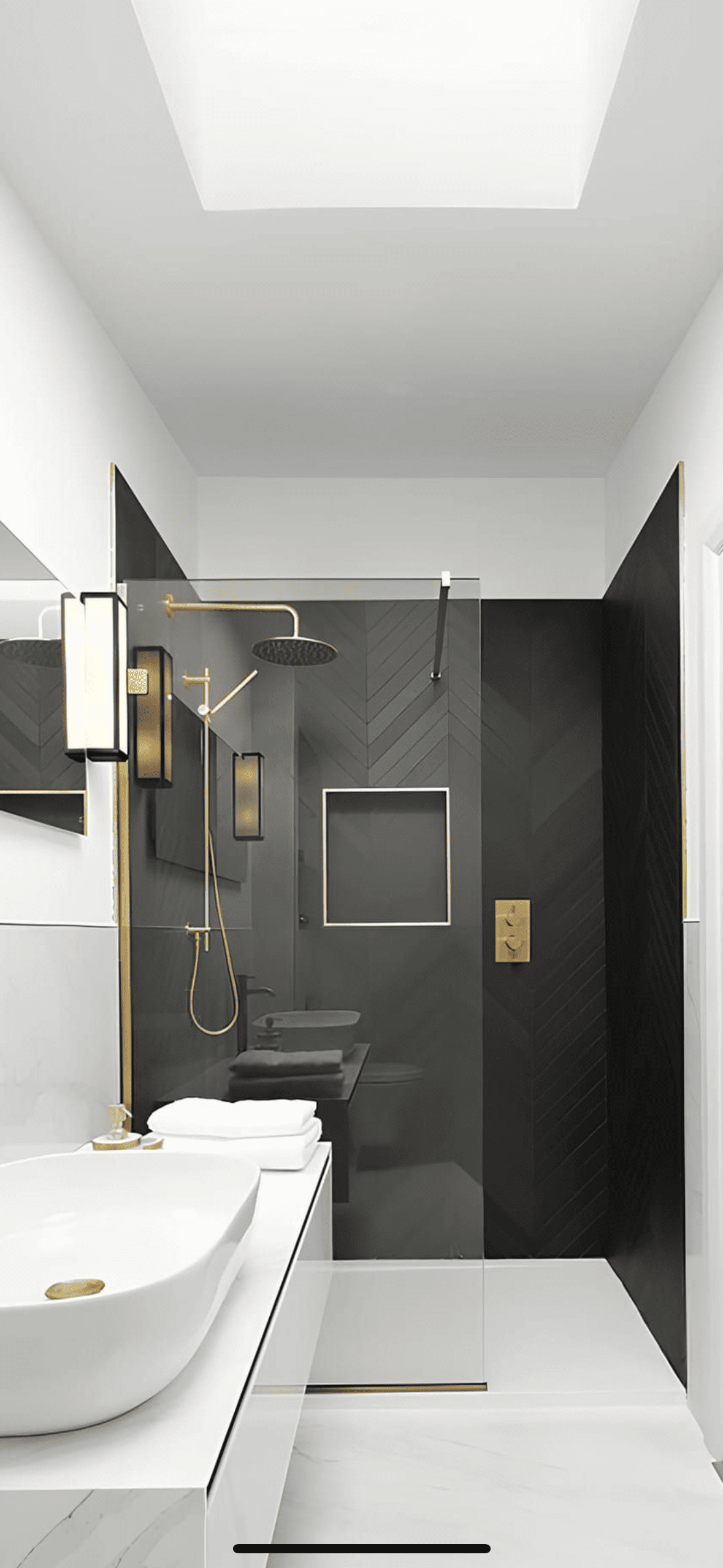 Bathroom with a charcoal herringbone tiled wall, a walk-in shower and brass fixtures