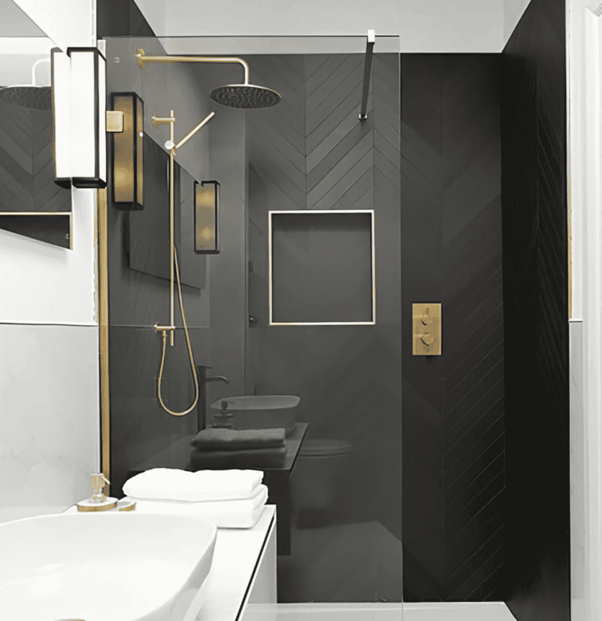 Completed bathroom with a charcoal herringbone tiled walk-in shower and brass fixtures