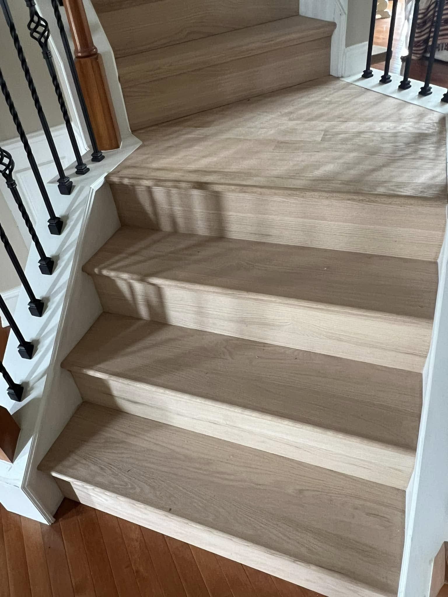 New white-oak stair treads with white risers and black iron balusters