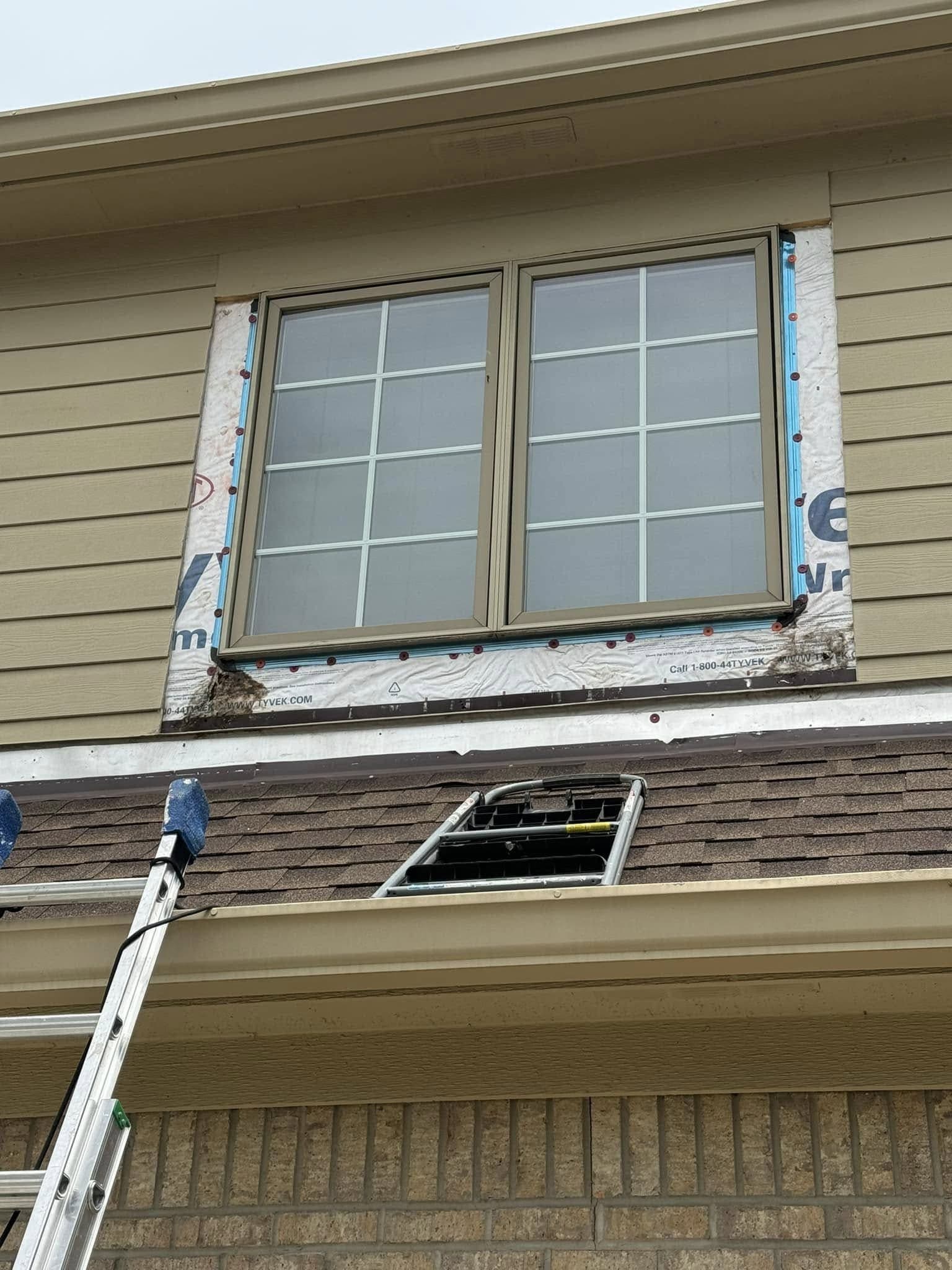 Replacement upstairs windows set into house wrap, with the siding still to go back on
